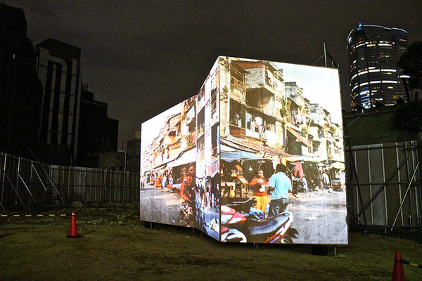岩井優「ホワイトビル・ウォッシング」。ビルが立ち並ぶ六本木の一角に、カンボジアのスラム街をプロジェクターで投影して見せた作品
